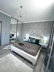 a bedroom with a large bed and a mirror at Luxurious Accommodation in Floreşti