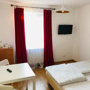 a bedroom with red curtains and a bed and a table at Viking in Dziwnów