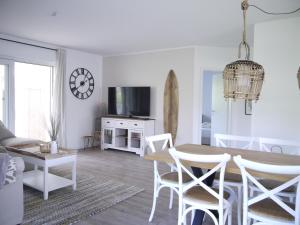 een witte woonkamer met een tafel en stoelen bij Ferienhaus Haffliebe in Scharbeutz