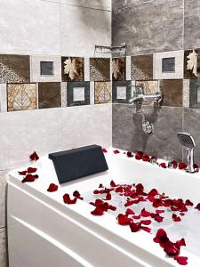 a bathroom with red roses on a bath tub at SEAVIEW HOTEL in Umm Lajj