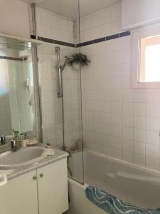 a bathroom with a tub and a sink and a shower at Loft, terrasse au soleil - Vue mer, à deux pas de tout in Wissant