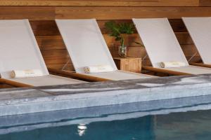 a row of chairs sitting next to a swimming pool at Le Balamina in Porto-Vecchio
