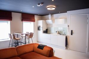 a living room with a couch and a kitchen at "DE BANK" - Hotel Apartments in Harlingen
