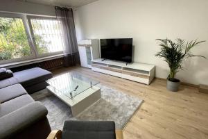 a living room with a couch and a tv at Modern Terrace Apartment Free Wifi Free Parking and Netflix in Hamm