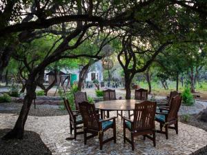 a table and chairs under a tree in a park at The Castello at Kruger in Marloth Park