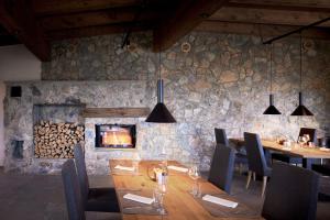 a dining room with a table and a stone wall at Puitalm - Natur I Apart I Hotel in Arzl im Pitztal