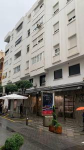 a large white building on the side of a street at Apartamento Central A in Algeciras