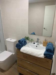 a bathroom with a sink and a toilet and a mirror at Apartamento Central A in Algeciras