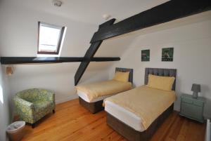 1 dormitorio con 2 camas, silla y ventana en The Arch An Capall Dubh Dingle, en Dingle