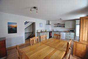 a kitchen with a wooden table and wooden chairs at The Arch An Capall Dubh Dingle in Dingle