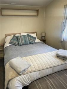 The Hideaway Cabin في Seasalter: سرير عليه وسادتين في غرفة