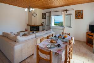 a living room with a table and a couch at Ranias Case Dell Olivetto in Gaios