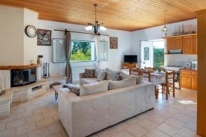 a living room with a large couch and a kitchen at Ranias Case Dell Olivetto in Gaios