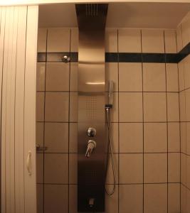 La salle de bains est pourvue d'une douche et de carrelage blanc. dans l'établissement Dream apartments limnionas, à Limnionas