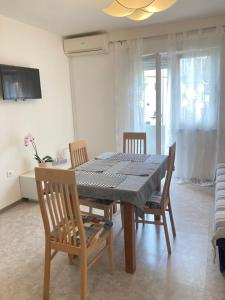 a dining room with a table and chairs and a television at App Goga in Umag