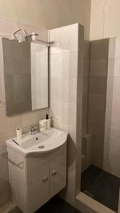 uma casa de banho com um lavatório branco e um espelho. em Aggelou Apartments em Spata