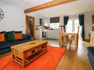 - un salon avec un canapé bleu et une table dans l'établissement Bluebell Cottage, à Ulverston