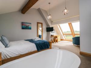 - une chambre avec un lit et une grande fenêtre dans l'établissement Bluebell Cottage, à Ulverston