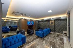 a waiting room with blue couches and a tv at SKYSTAR DELUXE HOTEL in Istanbul