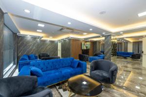 a living room with a blue couch and chairs at SKYSTAR DELUXE HOTEL in Istanbul