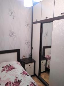 a bedroom with a bed and a mirror at Izi's cozy apartment in Kutaisi