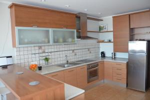 a kitchen with wooden cabinets and a stainless steel refrigerator at Panoramic Apt in the City center in Palanga +19 photos