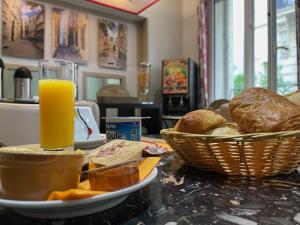 una mesa con un plato de pan y un vaso de zumo de naranja en Hotel de La Comédie, en Montpellier