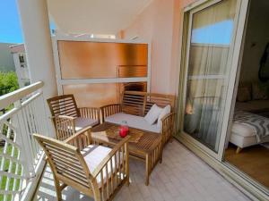 un patio con tavolo e sedie sul balcone. di POMPIDOU - 2 Chambres avec piscine, parking, Tennis, Juan a Vallauris