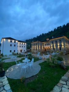 un patio con mesas y sillas por la noche en Hotel Kaso Ervehe en Përmet