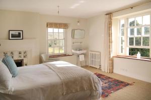a bedroom with a bed and a sink and windows at Wolford Lodge Traditional home surrounded 150 private acres with Tennis court in Honiton