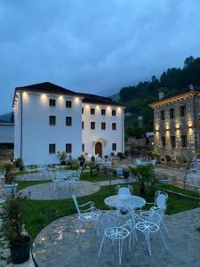 a group of tables and chairs in front of a building at Hotel Kaso Ervehe in Përmet