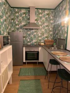 een keuken met een koelkast en een aanrecht met tapijten bij Largo da Rainha, Guesthouse in Merciana