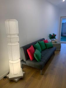 sala de estar con sofá y almohadas verdes y rojas en Largo da Rainha, Guesthouse en Merciana
