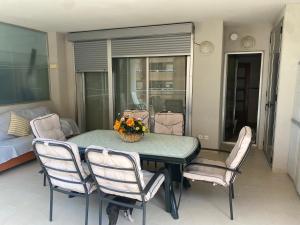 - une salle à manger avec une table, des chaises et un lit dans l'établissement Apartamento Marina D'Or 1º línea Edificio Mondrian, à Oropesa del Mar