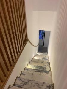 een trap met marmeren vloeren en verlichting erop bij Largo da Rainha, Guesthouse in Merciana