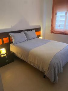 - une chambre avec un grand lit et deux lampes dans l'établissement Apartamento Marina D'Or 1º línea Edificio Mondrian, à Oropesa del Mar