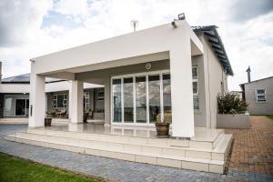 a white house with a large glass door at 36 Emanzini (Holiday home lake view) in Denysville