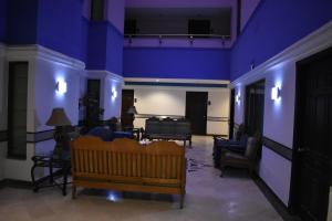 een kamer met paarse muren en een kamer met stoelen en een tafel bij Grand Regency Hotel in Pothi