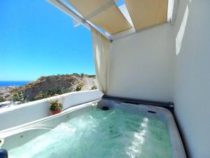 una vasca da bagno in una camera con vista sull'oceano di Amazing Vineyard View Luxury Villa with juccuzi! a Emporio