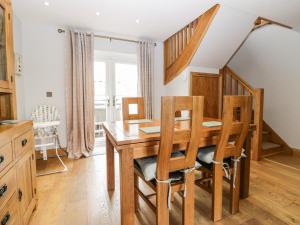 a dining room with a wooden table and chairs at Primrose Cottage in Ulverston