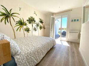 een slaapkamer met een bed en palmbomen aan de muur bij Maison de vacances "L'Embrun Marin" in Brem-Sur-Mer