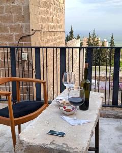 un tavolo con un bicchiere di vino e una bottiglia di TUĞMANER Small House AJAR a Mardin