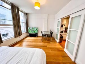 um quarto com uma cama, uma mesa e cadeiras em Deluxe Entire Apartment Between Covent Garden and St Pauls Cathedral em Londres