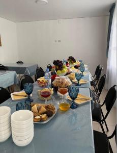 une longue table avec des assiettes de nourriture dans l'établissement Гостевой дом KOLSAY ROOM, à Saty