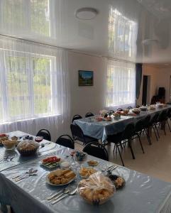 a group of tables with plates of food on them at Гостевой дом KOLSAY ROOM in Saty