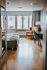 - une chambre avec un lit, une chaise et un bureau dans l'établissement Clarion Collection Hotel Majoren, à Skövde