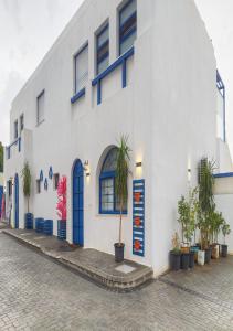 a white building with blue doors and a palm tree in front at Lara Family Resorts in Mukāwir