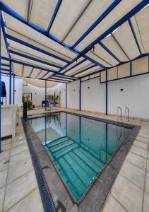 une piscine intérieure aux poutres bleues dans l'établissement Lara Family Resorts, à Mukāwir