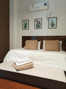 Una cama con dos sábanas blancas y toallas. en El Cardon - p/6 pax -2 dorm - Amplio y moderno en Salta