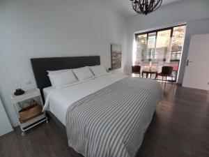 a bedroom with a bed with a black and white comforter at NEW CENTRAL LOFT- El verodal de Sabino in Santa Cruz de Tenerife